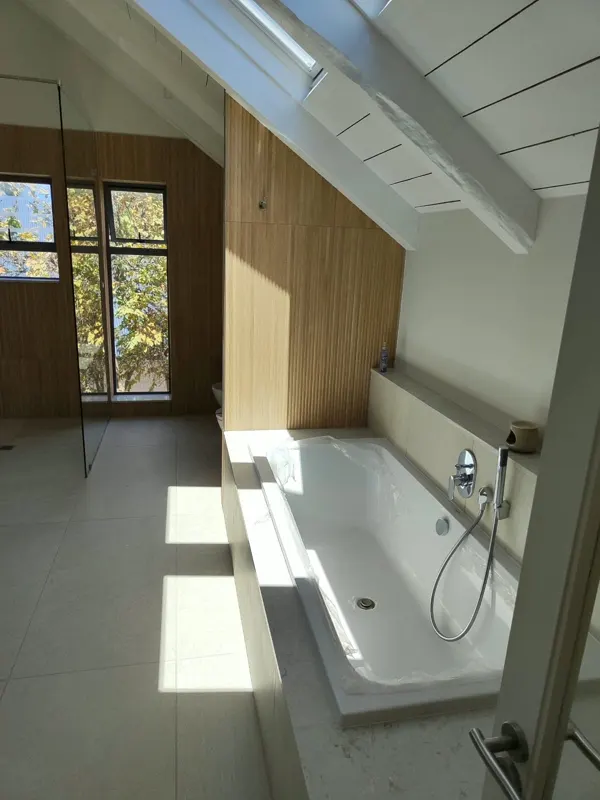Attic bathroom with skylight, built-in bath and hand shower