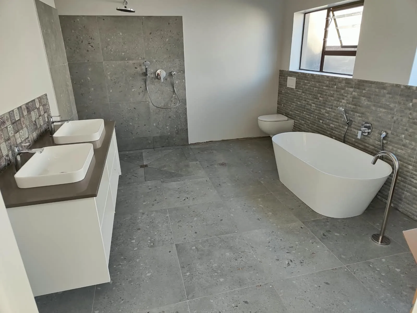 Modern bathroom with freestanding bath, floor-standing filler and walk-in shower